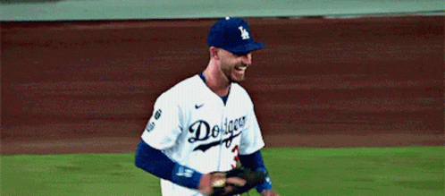 A Dodgers Baseball Player Is Smiling And Holding A Glove GIF
