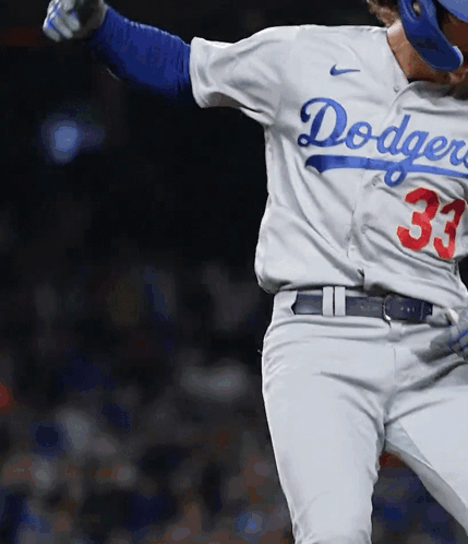 A Dodgers Baseball Player Wearing Number 33 Is Swinging His Bat GIF