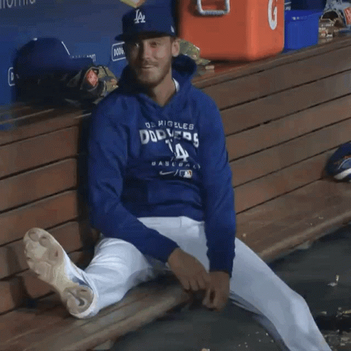 A Dodgers Player Sits On A Bench With His Legs Crossed GIF