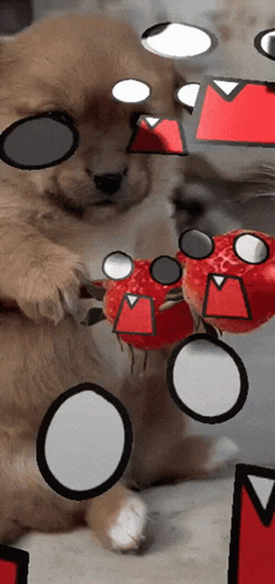 A Dog Holding A Strawberry With A Cartoon Face On It 'S Face GIF