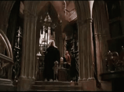 A Dog Is Laying On The Ground In Front Of A Man In A Cape . GIF