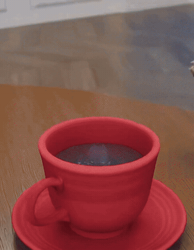 A Dog 'S Paw Rests On A Red Cup Of Coffee On A Saucer GIF