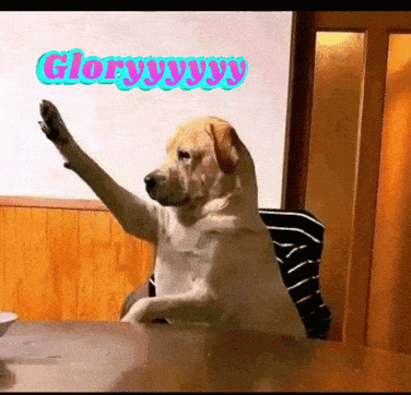 A Dog Sitting At A Table With Its Paw Up And The Words Glory Yy Yy Written On The Wall Behind It GIF
