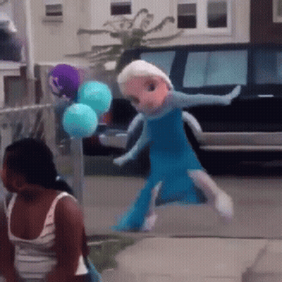 A Doll Dressed As Elsa From Frozen Is Walking Down A Sidewalk GIF