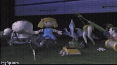 A Doll In A Blue Dress Standing Next To A Dinosaur GIF