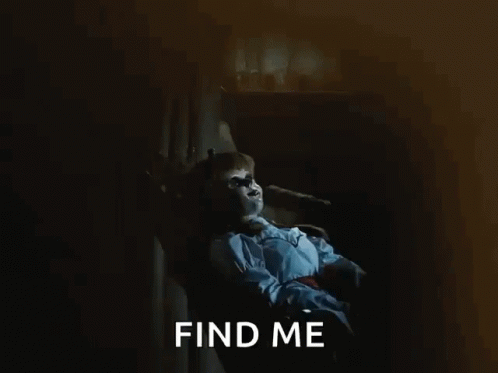 A Doll Is Sitting In A Chair With The Words Find Me Behind It GIF