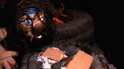 A Doll With A Blue Headband Is Eating S'mores GIF