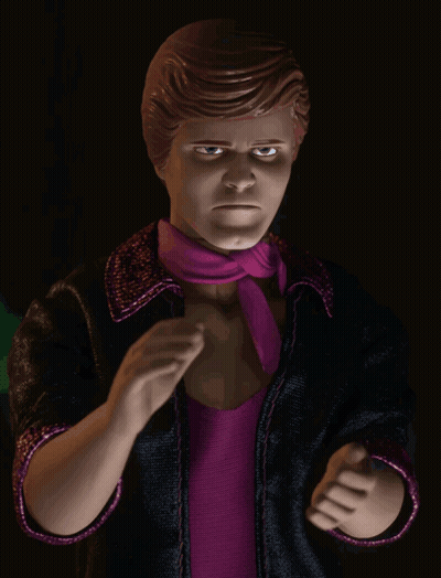 A Doll With A Purple Scarf Around His Neck And A Black Jacket GIF