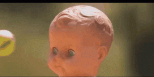 A Doll With Green Eyes Is Looking At The Camera . GIF