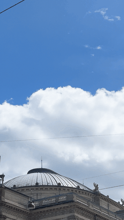 A Dome Shaped Building With A Blue Sky And Clouds Behind It GIF