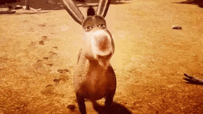 A Donkey From Shrek Is Standing In A Field Looking At The Camera . GIF