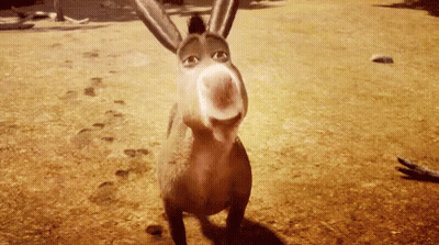 A Donkey From Shrek Is Standing On A Dirt Field Looking At The Camera . GIF