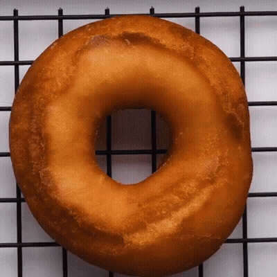 A Donut Is Sitting On A Wire Rack GIF