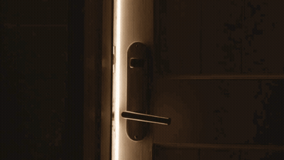 A Door Is Open To A Dark Room With A Light Shining Through It GIF