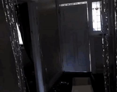 A Door Is Open To A Hallway With A Large Piece Of Paper In The Doorway GIF