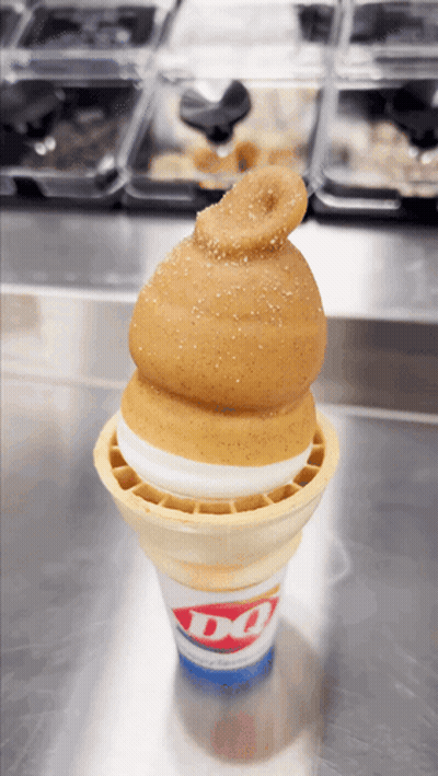 A Dq Ice Cream Cone With A Hamburger On Top GIF