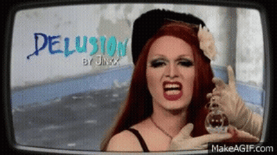 A Drag Queen Is Holding A Bottle Of Perfume In Front Of Her Face And Screaming . GIF