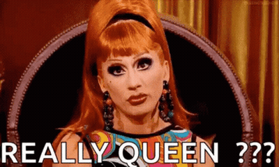 A Drag Queen Is Sitting In A Chair With The Words `` Really Queen '' Written On Her Face . GIF
