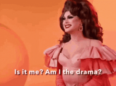 A Drag Queen Is Standing In Front Of An Orange Background And Asking Is It Me ? Am I The Drama ? GIF