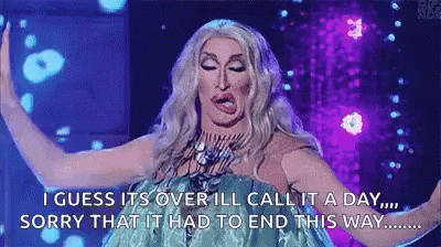 A Drag Queen Is Standing On A Stage With Her Arms Outstretched . GIF