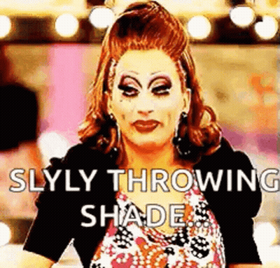 A Drag Queen Is Throwing Shade At The Camera While Wearing Makeup . GIF