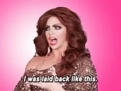 A Drag Queen Says I Was Laid Back Like This On A Pink Background GIF