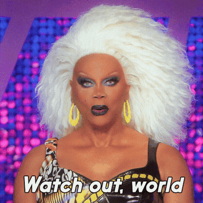 A Drag Queen Says " Watch Out World " While Wearing A Wig GIF