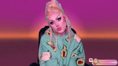 A Drag Queen Wearing A Green Hoodie With Avocados On It GIF
