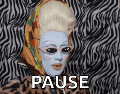 A Drag Queen With A Scarf Around Her Head And The Word Pause Behind Her GIF