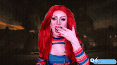 A Drag Queen With Red Hair And Freckles Is Pointing At Something GIF
