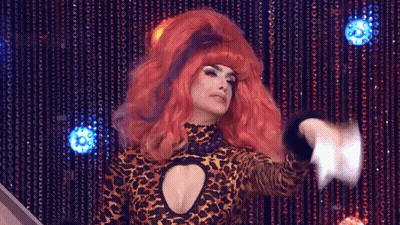 A Drag Queen With Red Hair Is Wearing A Leopard Print Dress GIF