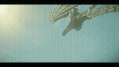 A Dragon Is Flying Through The Air With Its Wings Spread . GIF