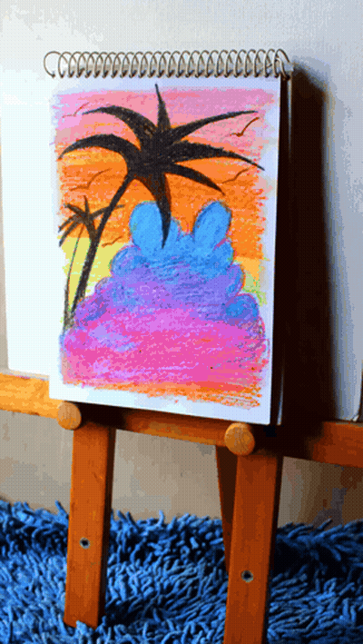 A Drawing Of A Sunset With Palm Trees Is On A Wooden Easel GIF