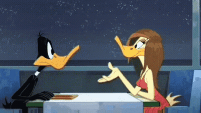 A Duck And A Woman Are Sitting At A Table In A Diner GIF