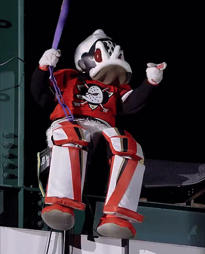 A Duck Mascot Is Holding A Bat And Wearing A Shirt That Says Ducks On It GIF