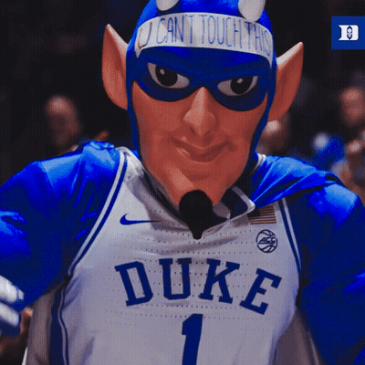A Duke Basketball Mascot Wearing A Devil Costume And A Sign That Says " I Can 'T Touch This " GIF