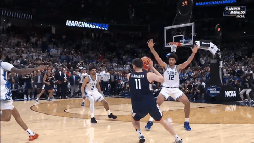 A Duke Basketball Player Wearing Number 11 Tries To Block A Shot From A Duke Player Wearing Number 12 GIF