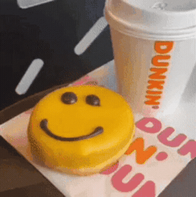 A Dunkin Donut With A Smiley Face On It GIF