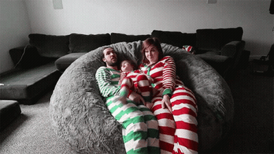 A Family Is Laying On A Bean Bag Chair Wearing Striped Pyjamas GIF