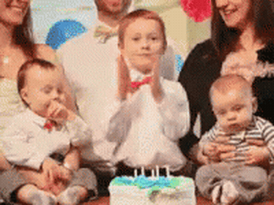 A Family Is Posing For A Picture In Front Of A Birthday Cake . GIF