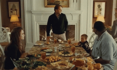 A Family Is Sitting Around A Table With Plates Of Food And Drinks . GIF