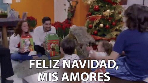 A Family Is Sitting On The Floor In Front Of A Christmas Tree With The Words Feliz Navidad Mis Amores Above Them GIF