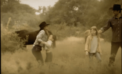 A Family Walking In A Field With A Horse GIF