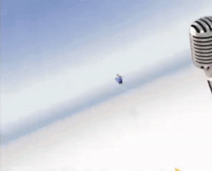 A Fat Cartoon Character Is Flying Through The Air Next To A Microphone . GIF