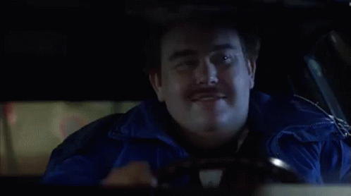 A Fat Man In A Bow Tie Is Driving A Car And Looking Out The Window . GIF