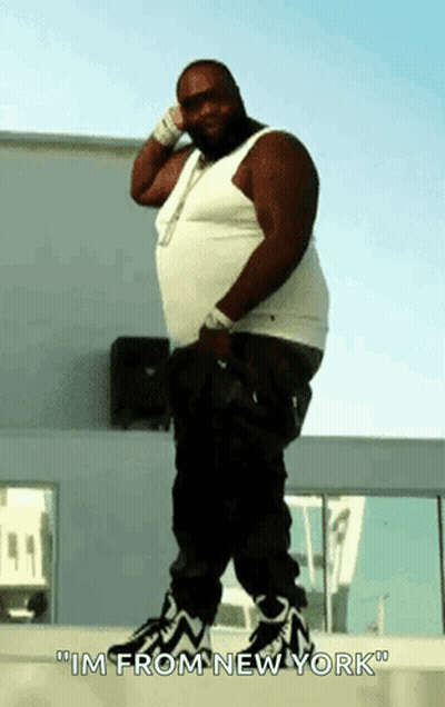 A Fat Man In A White Tank Top And Black Pants Says " Im From New York " GIF