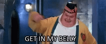 A Fat Man In A Yellow Jacket And Hat Is Saying `` Get In My Belly '' While Holding A Light . GIF