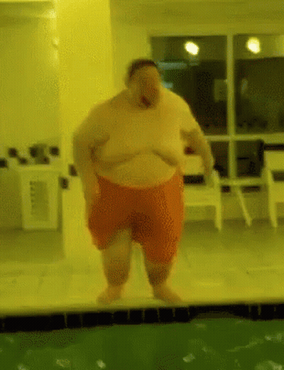 A Fat Man In Orange Shorts Is Standing Next To A Pool GIF