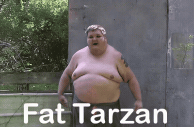 A Fat Man Is Standing In Front Of A Fence With The Words Fat Tarzan Written On It GIF