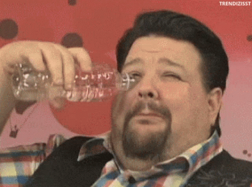A Fat Man With A Beard Is Drinking Water From A Plastic Bottle GIF